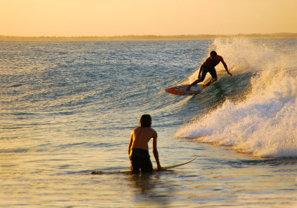 SURFING: Surfere bruker aldri vest, men er bundet til brettet som er et effektivt flytemiddel.