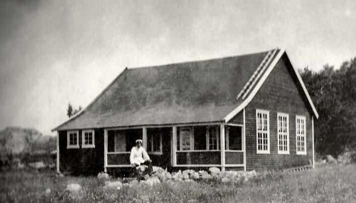 Bildet er fra 25. juli 1917. Formann Elvin Kleiberg sitter foran hytten og beundrer det de har skapt. Bildet er fra 25. juli 1917. Formann Elvin Kleiberg sitter foran hytten og beundrer det de har skapt.