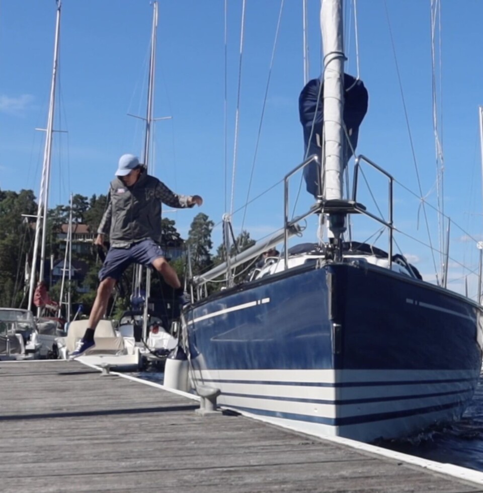 1: En i baugen hopper i land med springet som er festet til midten av båten.