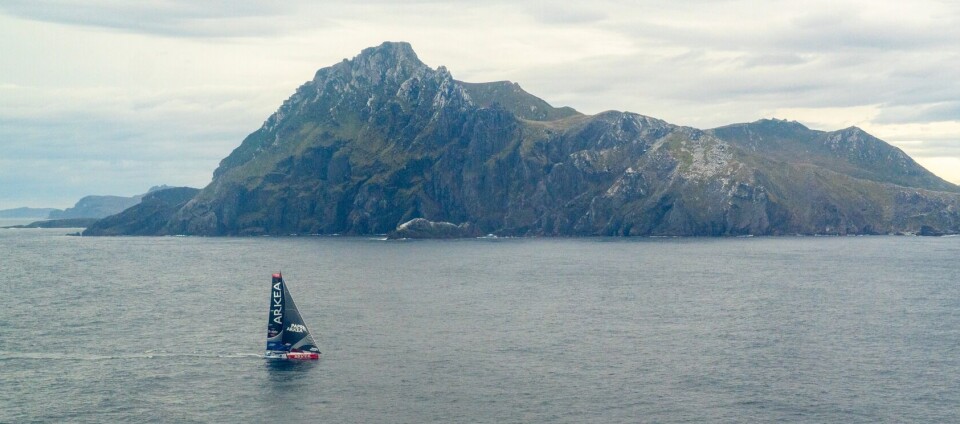 KAPP HORN: PAPREC ARKÉA med landdetmerket i bakgrunnen. RACE, DECEMBER 24, 2024 : PAPREC ARKÉA skipper Yoann Richomme (FRA) is photographed rounding Cape Horn in first place during the Vendee Globe sailing race on December 24, 2024. (Photo by Vendee Globe)