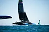 F50-foilkatamaraner fra SailGP seiler raskt på foiler i solfylt vær til havs.