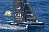 Foilende Orient Express Racing Team-seilbåt passerer en Louis Vuitton-merket bøye på blått hav.