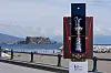 America’s Cup-trofé i åpent Louis Vuitton-etui på promenade med Castel dell’Ovo i bakgrunnen.