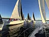Seilbåter i regatta på stille vann i lav kveldssol