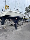 Seilbåt på land i en marina med en person som står ved siden av.