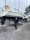 Seilbåt på land i en marina med en person som står ved siden av.