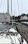 Fortøyd seilbåt ved kai med master, tauverk og andre båter i en småbåthavn.