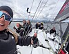 Seilere om bord på en regattabåt med seil og rigg i vind og bølger.