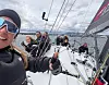 Seilere om bord på en regattabåt med seil og rigg i vind og bølger.