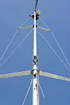 Seilmast med strekkstag fotografert nedenfra mot blå himmel.