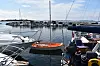 Små båter og seilbåter ligger fortøyd ved en marina med rolig vann.