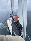 Person tar selfiebilde på dekk på en seilbåt ute på åpent hav.