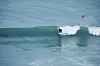 Surfer rir på en bølge i turkist hav.